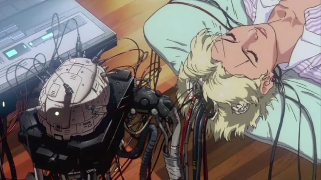 نمایی از یک صحنه‌ی سایبرپانکی در انیمه Ghost in the Shell؛ زنی با موهای کوتاه روشن به پشت روی زمین دراز کشیده و چشم‌هایش بسته است، در حالی که کابل‌ها و سیم‌های متعددی از گردن و سر او به دستگاه‌ها و یک مغز مصنوعی متصل شده‌اند. تصویر مفاهیم پیوند انسان و ماشین، خودآگاهی و هویت را القا می‌کند.